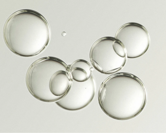 Clear water droplets on a reflective surface